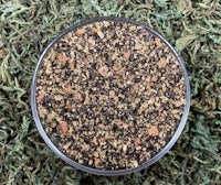 a bowl of pebbles on a green grass