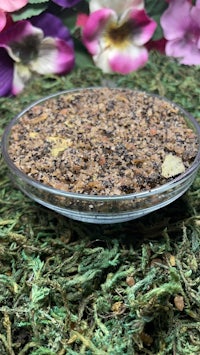 a bowl of seeds on top of moss and flowers