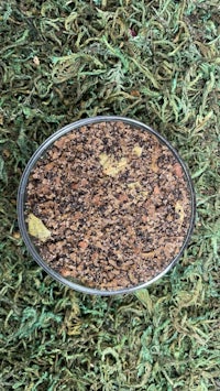 a bowl of pebbles on a green grass